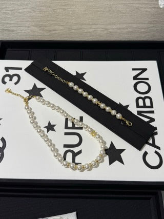 Chanel light gold bracelet with white pearls and full pavé-set stones.